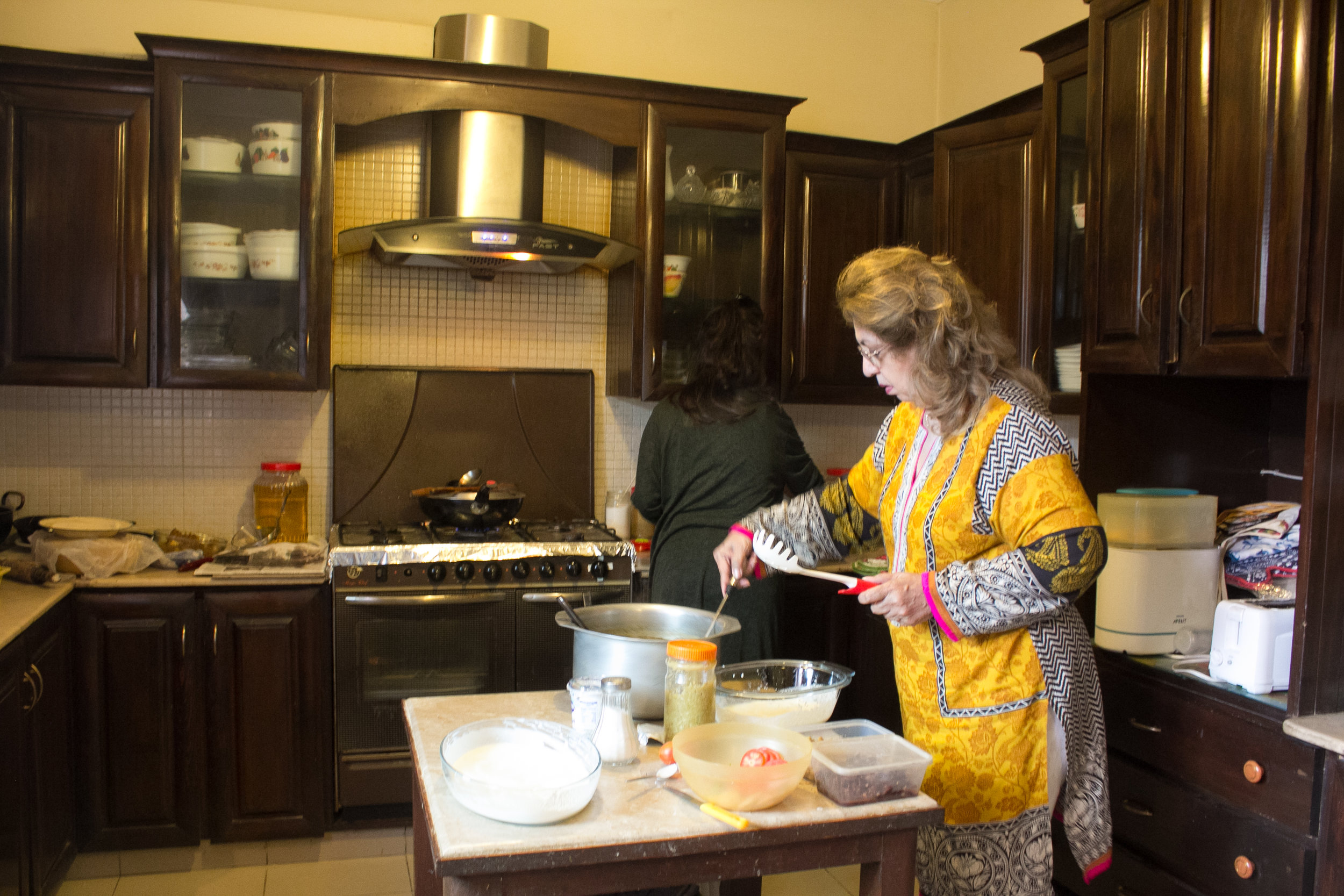 aunty preparing borani banjan in kitchen