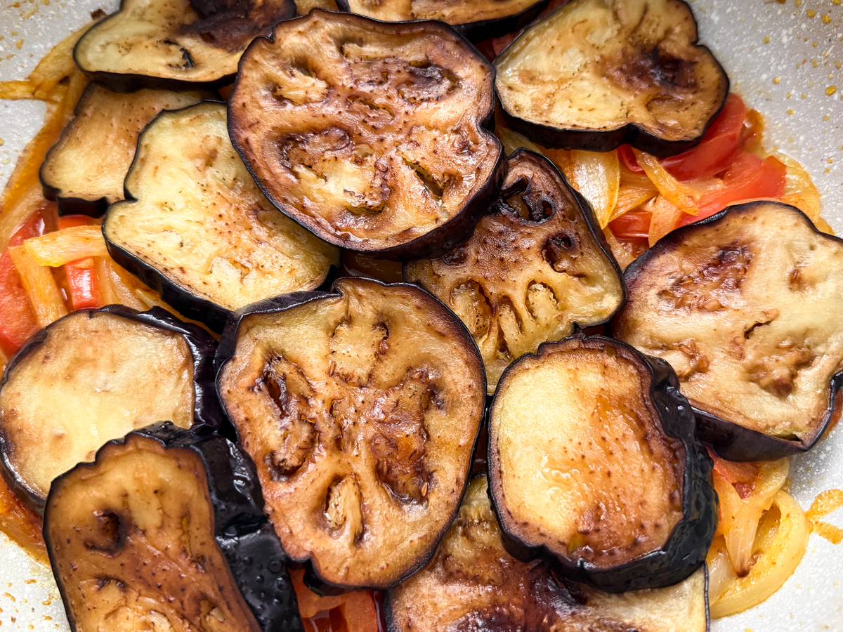 eggplant layered on top of the tomato and onion mixture 